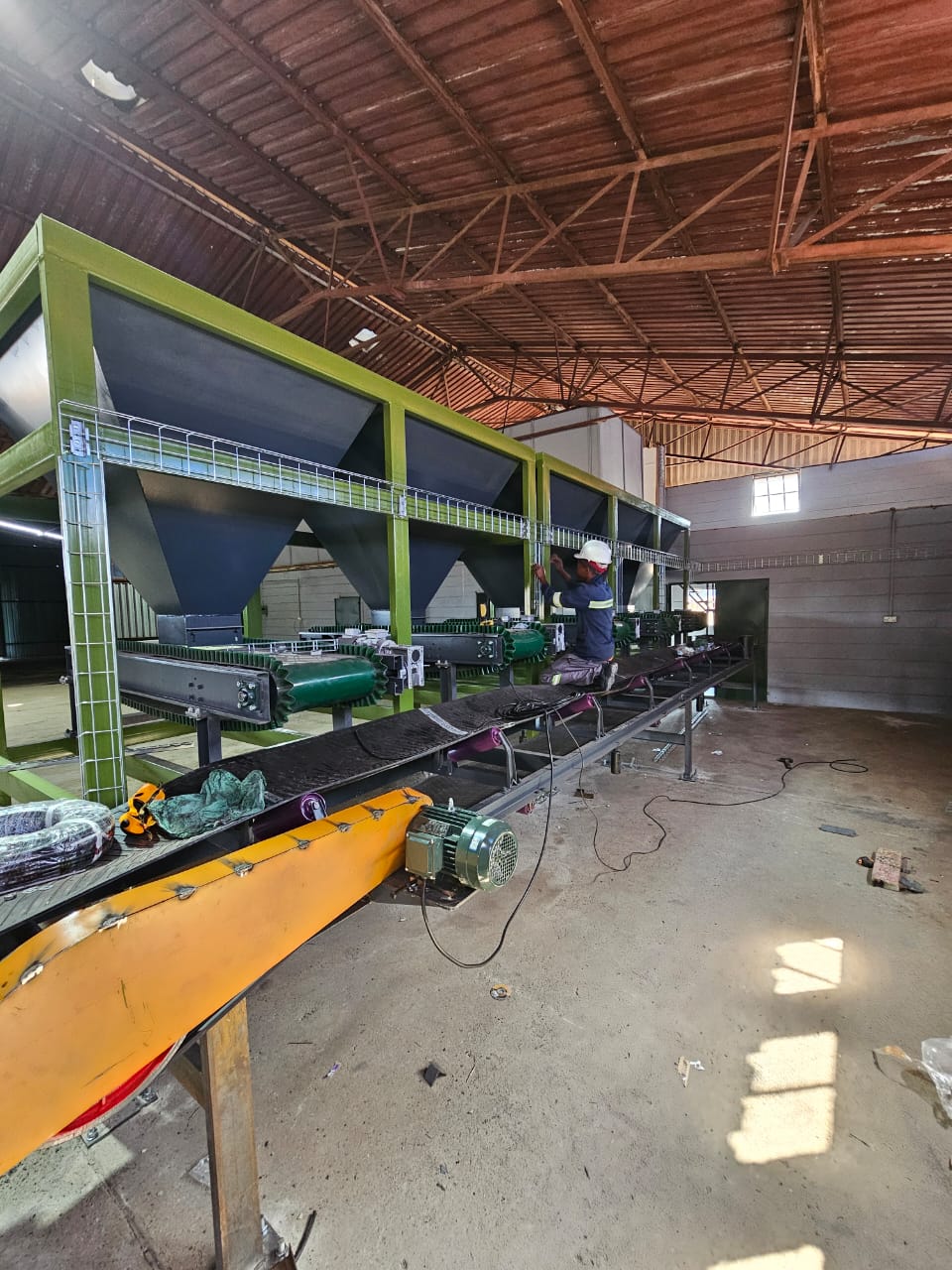 Technicians installing and commissioning a dynamic-batch fertilizer blending and bagging plant with PLC automation and electrical systems in Zimbabwe.